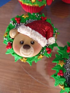 a teddy bear wearing a santa hat on top of cupcakes