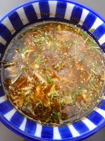 a blue and white bowl filled with soup on top of a table