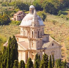 an aerial view of a church surrounded by trees