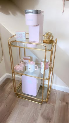 a gold shelf with pink and white items on it