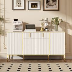 a white and gold sideboard with pictures on the wall