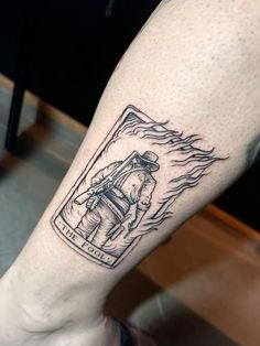 a man's leg with a tattoo on it that has an image of a firefighter