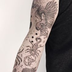 a man's arm with an eagle and crab tattoo on the left side of his arm