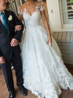 a man in a suit and tie standing next to a woman in a wedding dress