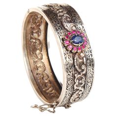 Russian Imperial period fine bangle in 84 Silver. Main attraction here is a Flower measuring 17 mm x 14 mm with natural and untreated medium Blue colored Sapphire 8 mm x 6.5 mm x 5 mm ca.2 ct surrounded with 12 baguette cut Rubies 2.25 mm x 2 mm /0.045 ct / ca 0.45 ctw. Ornamental divided Black Enameling work and stamped ornamentations. This bangle dates to ca. late XIX - early XX century. Hallmarked with Imperial period Russian 84 zolotniks silver marks used in late XIX early XX century before Russian Jewelry, Old Rings, Photo Equipment, Jewelry Workshop, Main Attraction, Silver Bangle Bracelets, Old Jewelry, Baguette Cut, Nature Bracelets