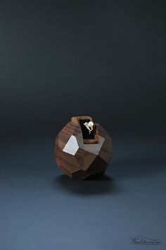 a wooden box with a ring on it sitting in the middle of a dark room