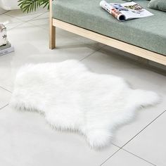 a white sheepskin rug is laying on the floor next to a couch and coffee table