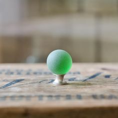 a green ball sitting on top of a wooden table