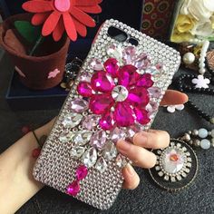 a woman's hand holding an iphone case with pink flowers on it