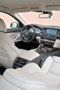 the interior of a modern car with all white leather seats and steering wheel, including center console