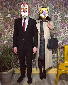 two people wearing masks standing next to each other