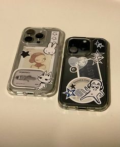 two cell phones sitting next to each other on a white counter top with stickers