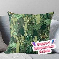 a green cactus pattern with the words support independent artists in pink on it throw pillow