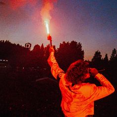 a woman holding up a lit candle in the air