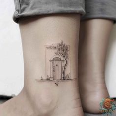 a woman's foot with a small house tattoo on the side of her leg