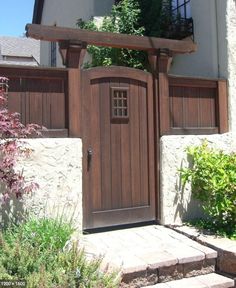 an entrance to a house with a wooden gate and brick steps leading up to it