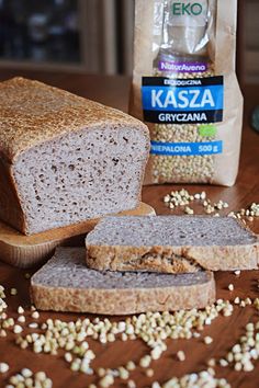 two slices of bread sitting on top of a wooden table next to a bag of kasa granola