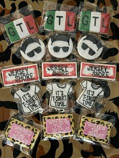 there are many decorated cookies in the shape of t - shirts and sunglasses on display