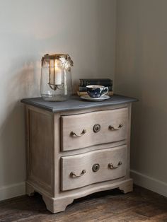 an old dresser has a candle on top