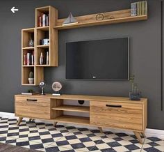 an entertainment center with bookshelves and a flat screen tv mounted on the wall