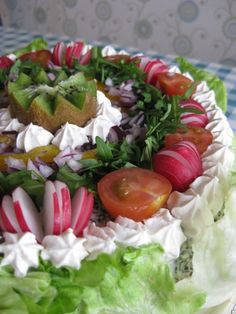 a cake decorated with lettuce, tomatoes and other vegetables