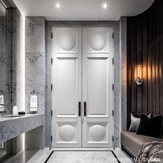 a bathroom with marble walls and flooring, two doors leading to a bathtub