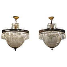 two chandeliers hanging from the ceiling with crystal beads and brass fittings on them