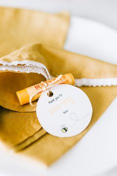 an orange and white tag sitting on top of a brown bag