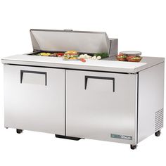 a stainless steel refrigeration unit with two trays and food on top