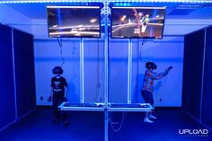 two children are playing video games in a room with blue walls and neon lights on the ceiling