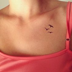 a woman's chest with two birds on the left side of her chest and one bird in the middle