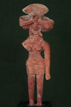 an ancient statue is displayed on a black stand