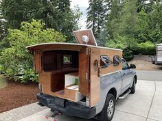 the truck is parked on the side of the road with it's back door open