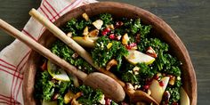 a wooden bowl filled with greens and apples