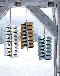 three wind chimes hanging from a wooden structure in the snow