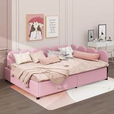 a pink bed sitting on top of a wooden floor