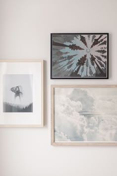 three framed photographs hang on the wall above a bed