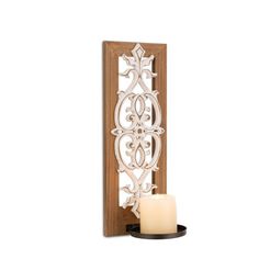 a candle holder with an intricate design on the front and back of it, holding a lit candle