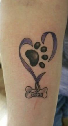 a tattoo on the leg of a woman with a dog's paw and heart