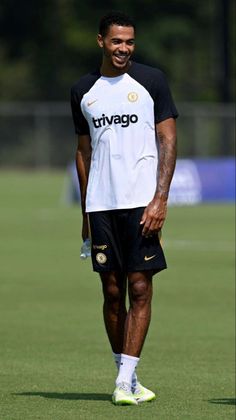 a man standing on top of a soccer field wearing a black and white shirt with the word trvago written on it