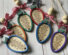 four wooden tags with words and bows hanging from strings on a white wood table top