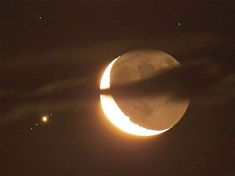 the moon is partially obscured by clouds as it passes in front of an earth - like object