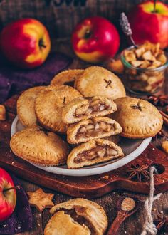 apple hand pies on a plate with apples and cinnamon sticks in the back ground