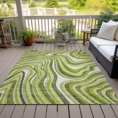 a green and white rug sitting on top of a wooden deck