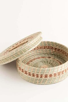 two woven baskets sitting next to each other on top of a white surface with one empty basket in the middle