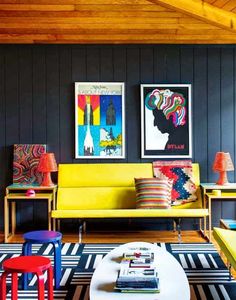 a living room filled with colorful furniture and pictures on the wall above it's coffee table