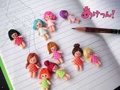 there are many dolls on the page with pencils next to it and a book