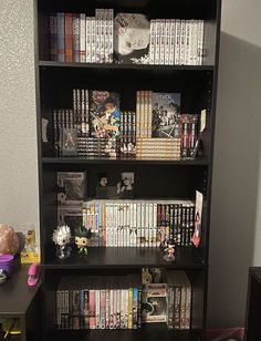 a bookshelf filled with lots of different types of dvds and games on top of it