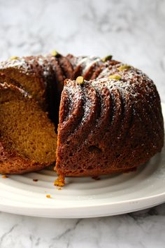 a bundt cake on a plate with one slice cut out