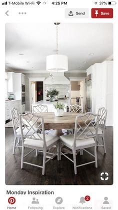 a dining room table with white chairs around it